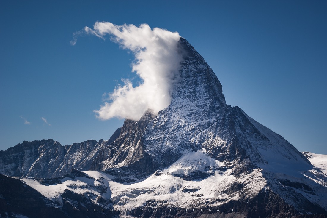 „Matterhorn mit markanter Wolkenfahne über Zermatt, Schweiz – Bergaufnahme bei klarem Himmel