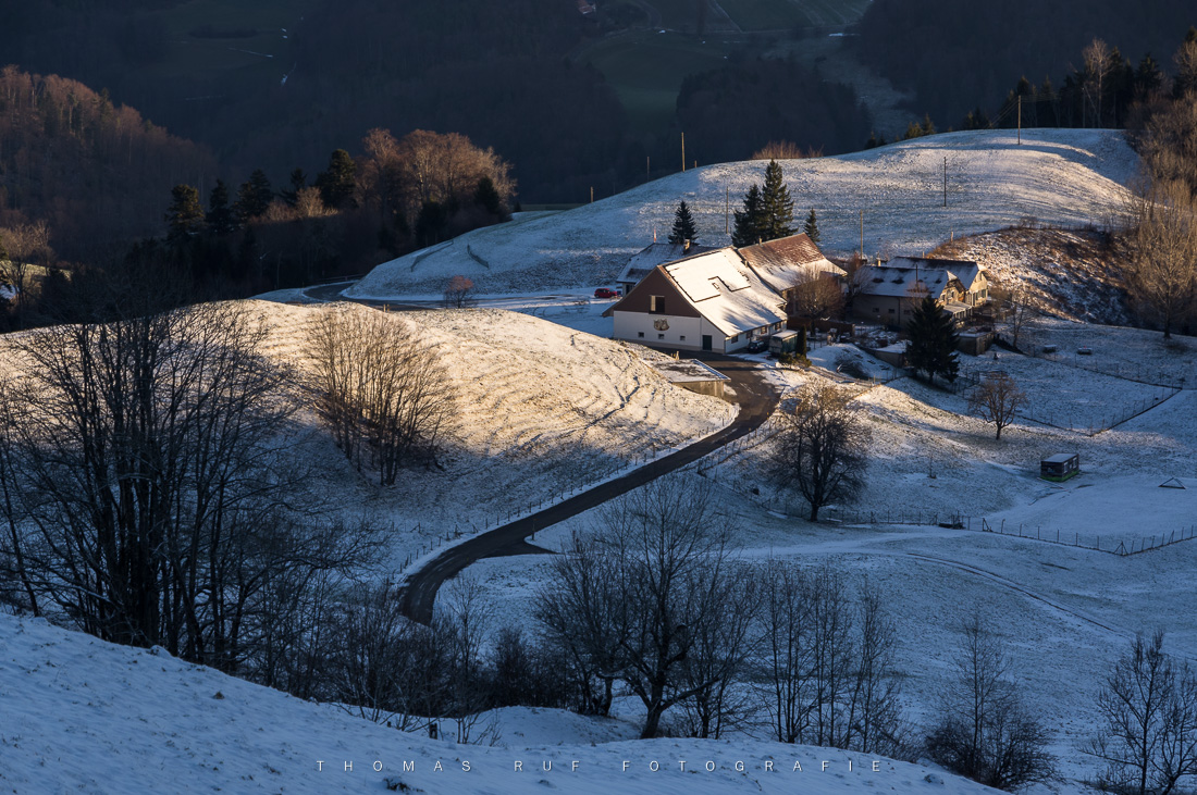 Winterliche Hügellandschaft mit Bauernhof – erste Sonnenstrahlen am Ober-Bölchen, Baselland